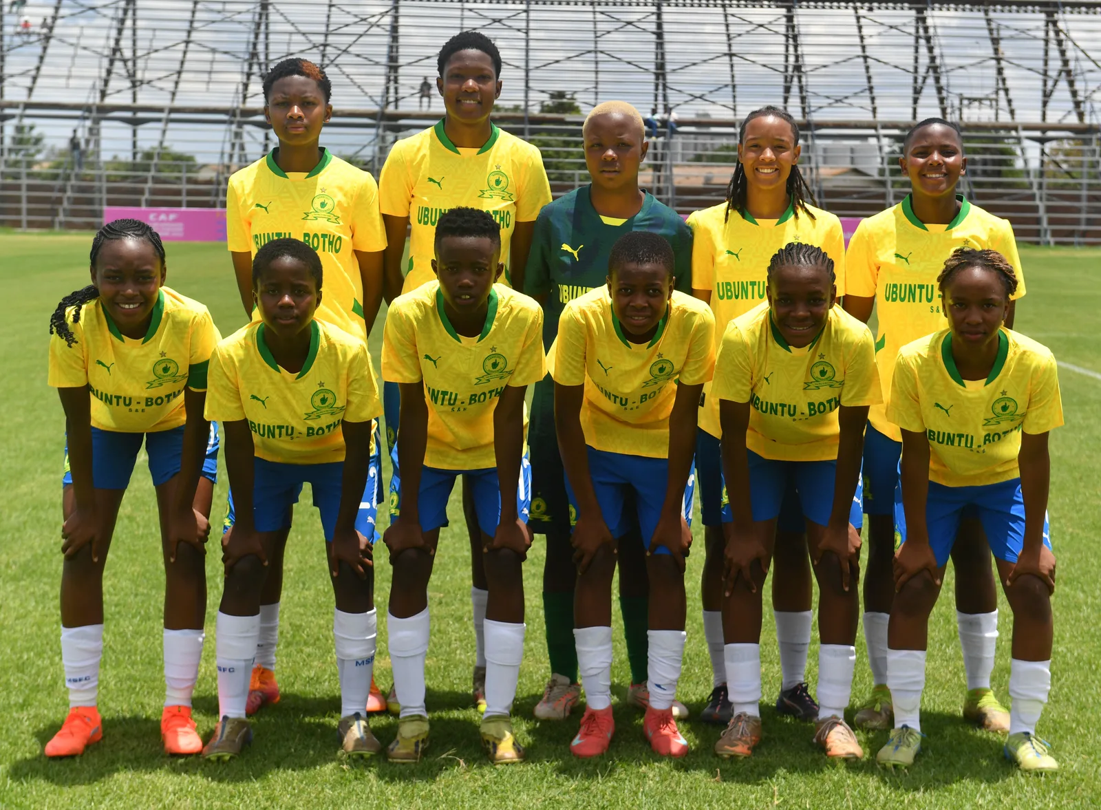 Mamelodi Sundowns squad in the club's yellow-and-green Puma kit carrying Ubuntu-Botho shirt sponsorship
